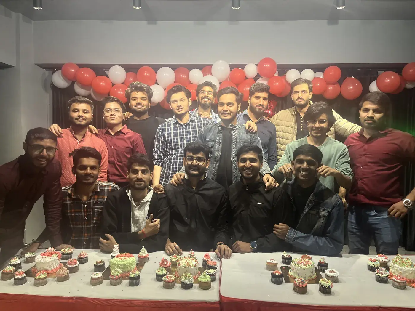 The team celebrating a milestone with cake and balloons